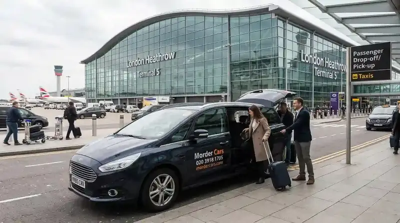 Passengers loading luggage into a dark MPV outside a Heathrow terminal building